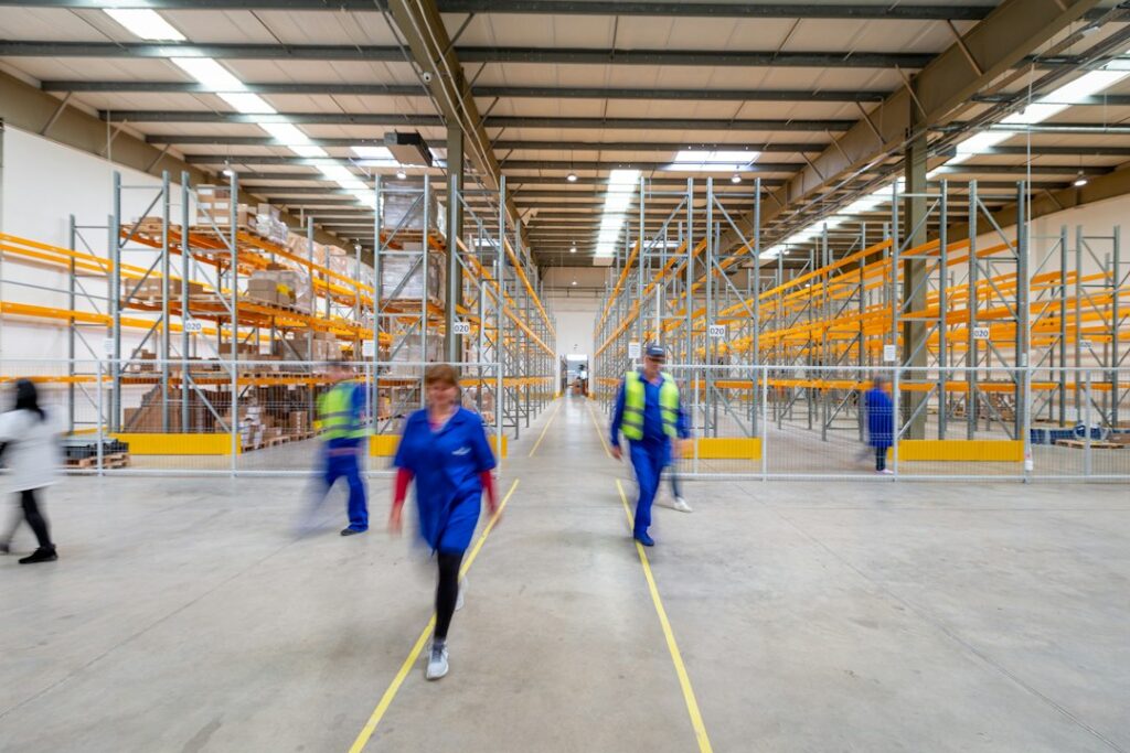 Équipe dans les allées d’un entrepôt logistique.