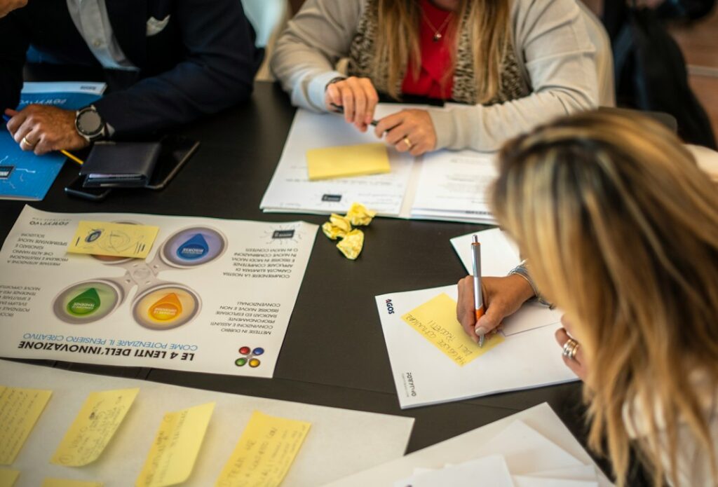 Illustration : plusieurs personnes organisent leur travail autour de documents sur une table claire.