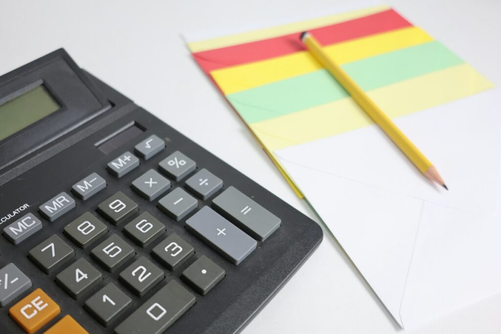 Calculatrice et carnet sur une surface blanche.