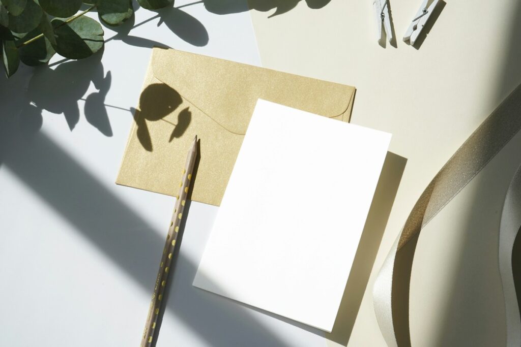Feuille blanche et enveloppe sur une table claire.