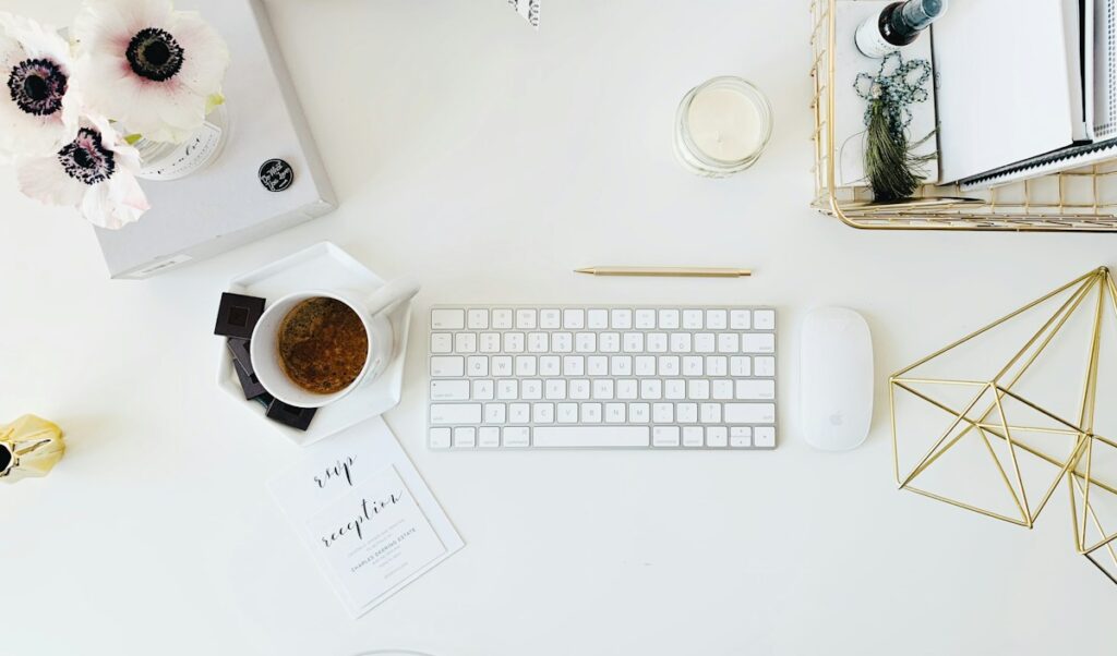 Clavier et fournitures disposés sur une table blanche.