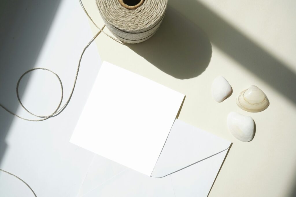 Feuille blanche et enveloppe sur une surface claire.