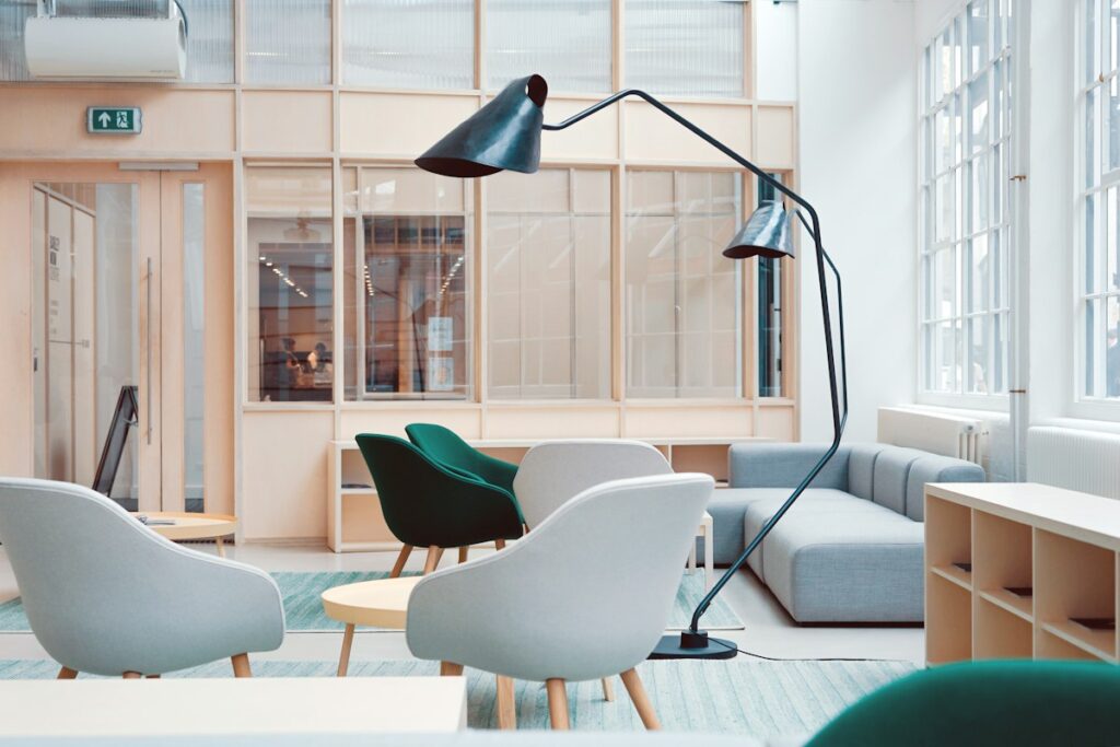 Espace de réunion lumineux avec des fauteuils et une table.