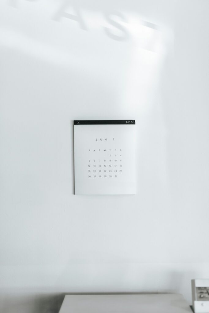 Petit calendrier suspendu à un mur blanc lumineux.