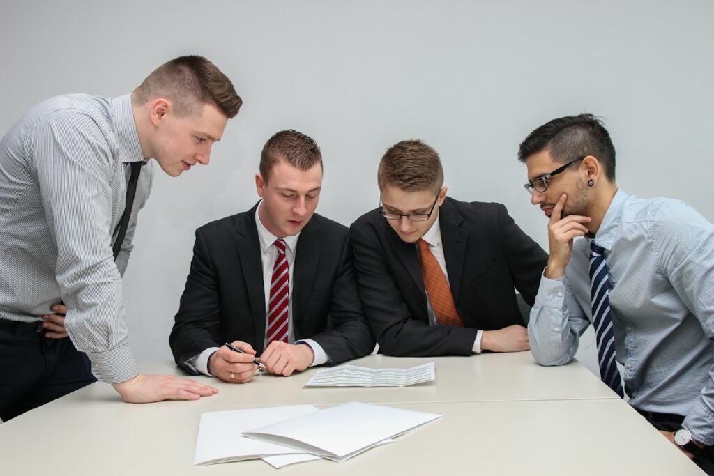 Équipe examinant un document autour d’une table blanche.