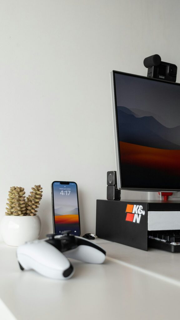 Poste informatique sobre avec écran et téléphone sur un bureau blanc.