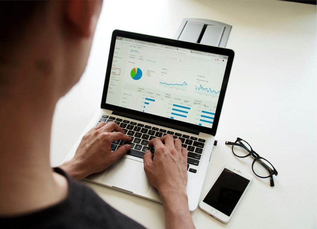 Ordinateur portable affichant un tableau de gestion sur un bureau blanc.