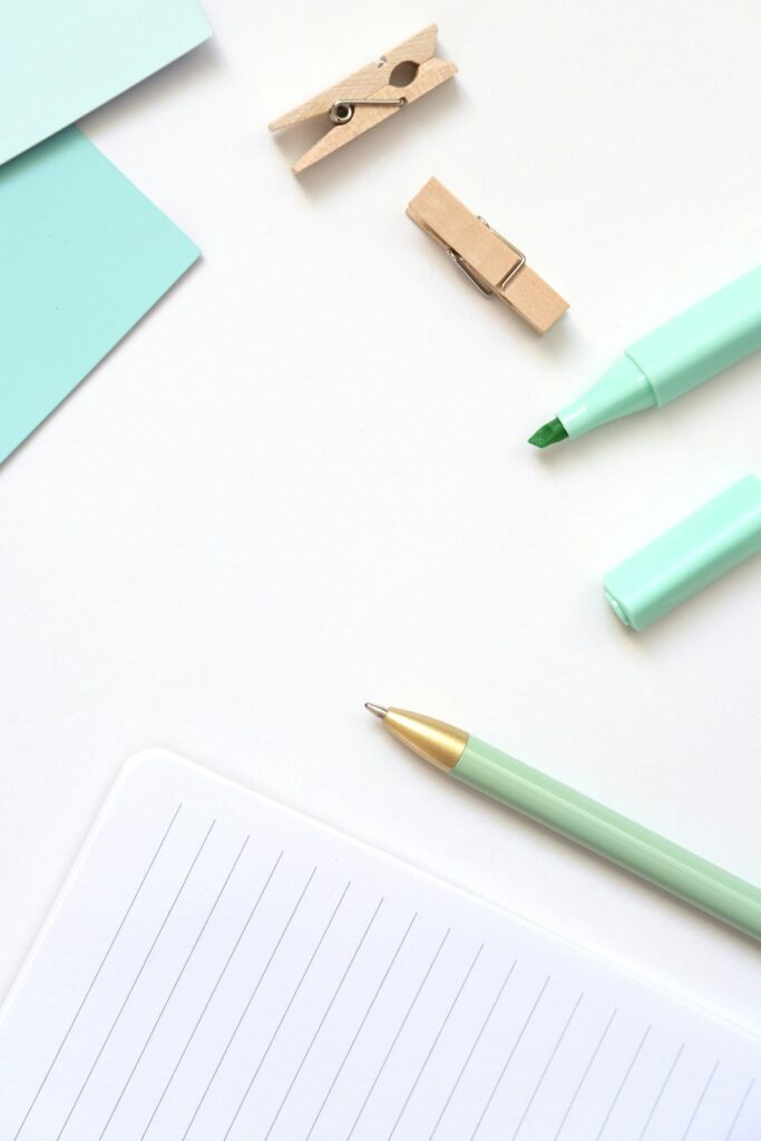 Petites fournitures de bureau vert menthe et carnet sur fond blanc.