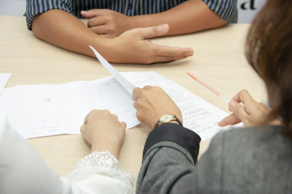 Échange de documents autour d’une table claire.
