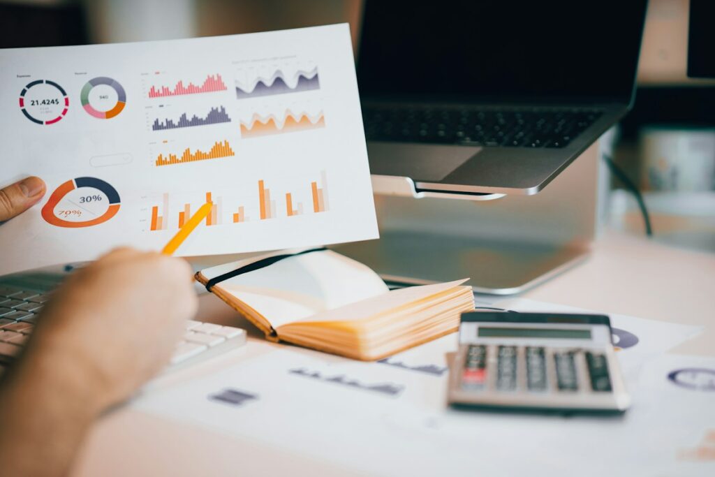 Personne examinant un document avec des graphiques à un bureau clair.