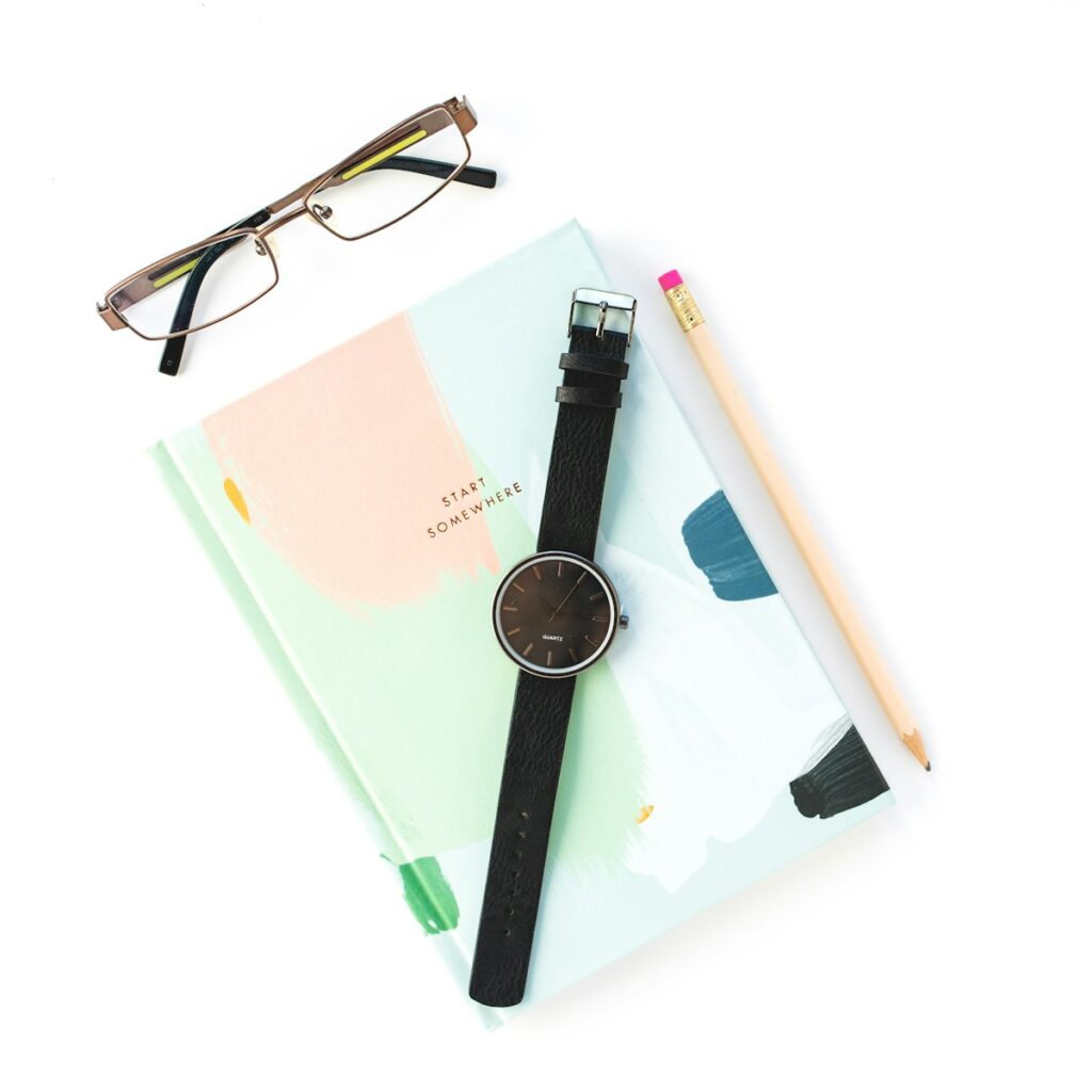 Documents, crayon et montre sur un fond blanc.