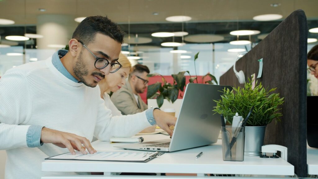 Professionnels travaillant à leurs bureaux dans un espace lumineux.