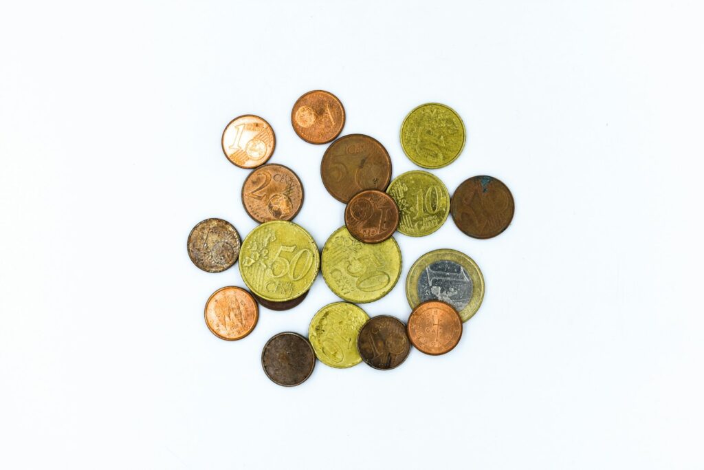 Pièces en euros et centimes disposées sur un fond blanc.